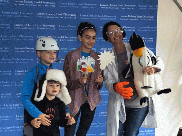 family poses with science props at the photo booth