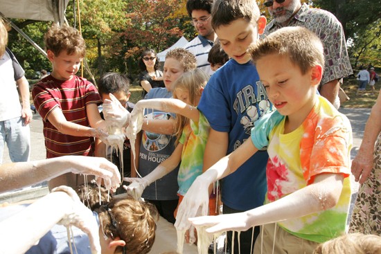 Kids feel the goopy cornstarch and water mix with their hands 