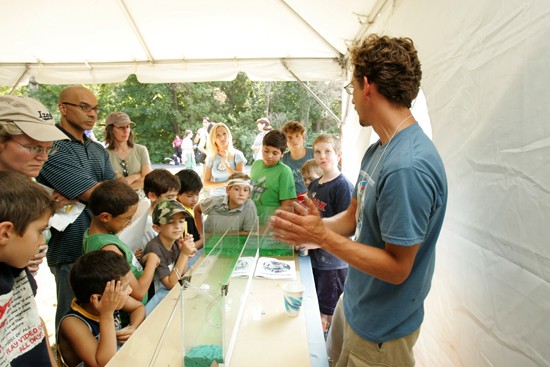 researcher explaining aquatic organisms to group of people