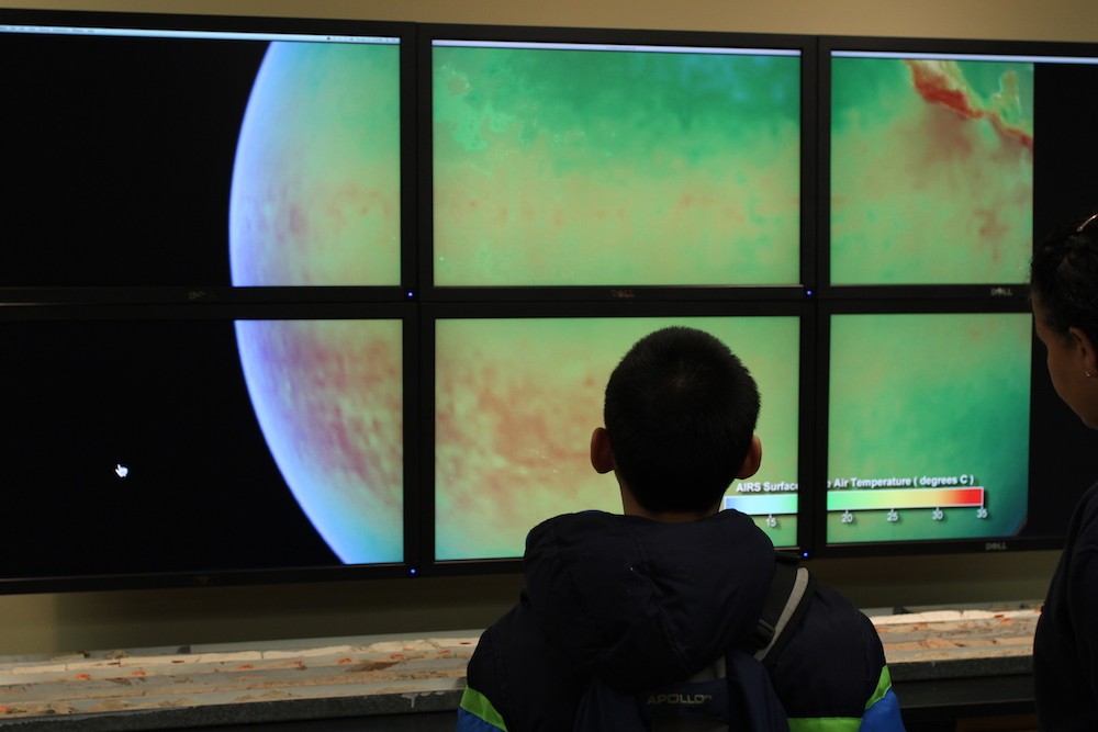 The Hyperwall in the Core Repository displays short videos about Earth and its climate. A child watches a video in the core repository