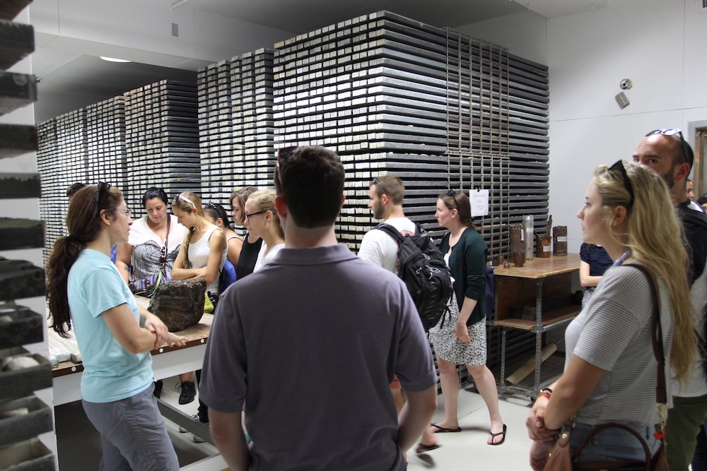 Racks of sediment cores dominate in one of three lockers in the Core Repository. Attendees look at racks of sediment cores