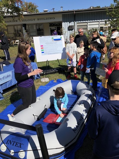 A scientist volunteer in the Biology and Paleo Environment exhibit shows visitors a raft similar to the ones they use when heading out to take core samples from the bottoms of lakes. Photo: Phebe Pierson