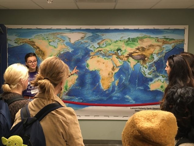 Lamont-Doherty’s Core Repository is one of the most extensive collections of deep sea sediment cores in the world. Here, a Barnard College undergraduate shows off a map of hundreds of sites where Lamont scientists have drilled into the seabed to collect the cores, which provide a window into past climate conditions. Photo: Sarah Fecht