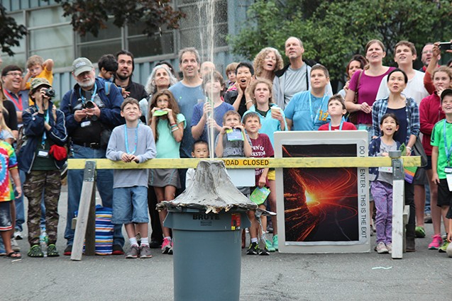 group looks on during trash can volcano eruption