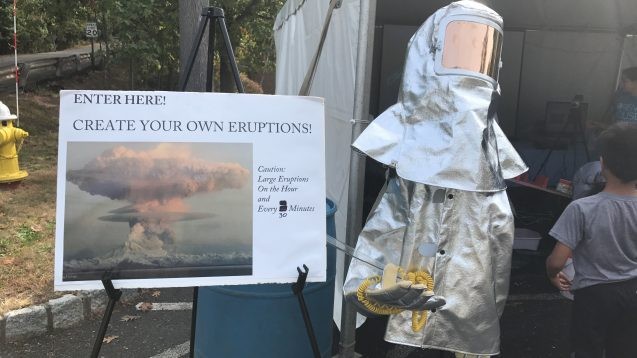 volcano suit in front of "create your own eruptions" sign