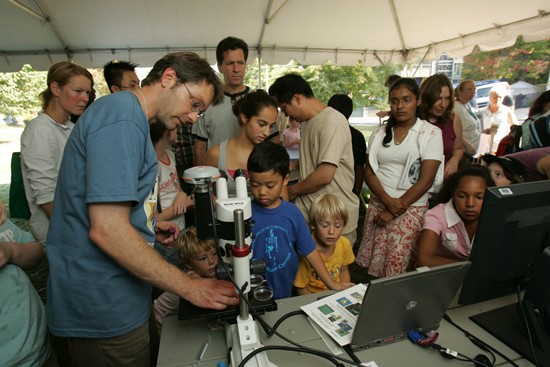group of people looking into microscope
