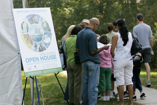 group of attendees and Open House poster