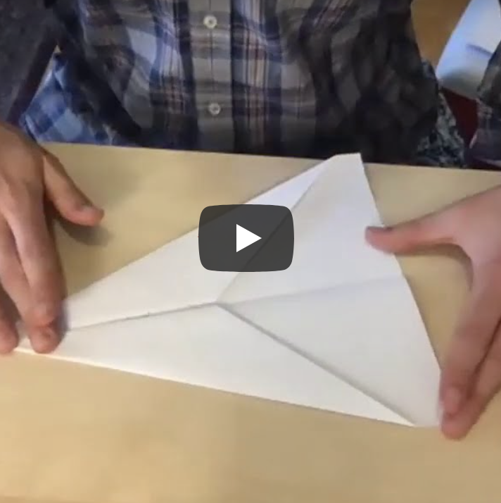hands folding paper airplane